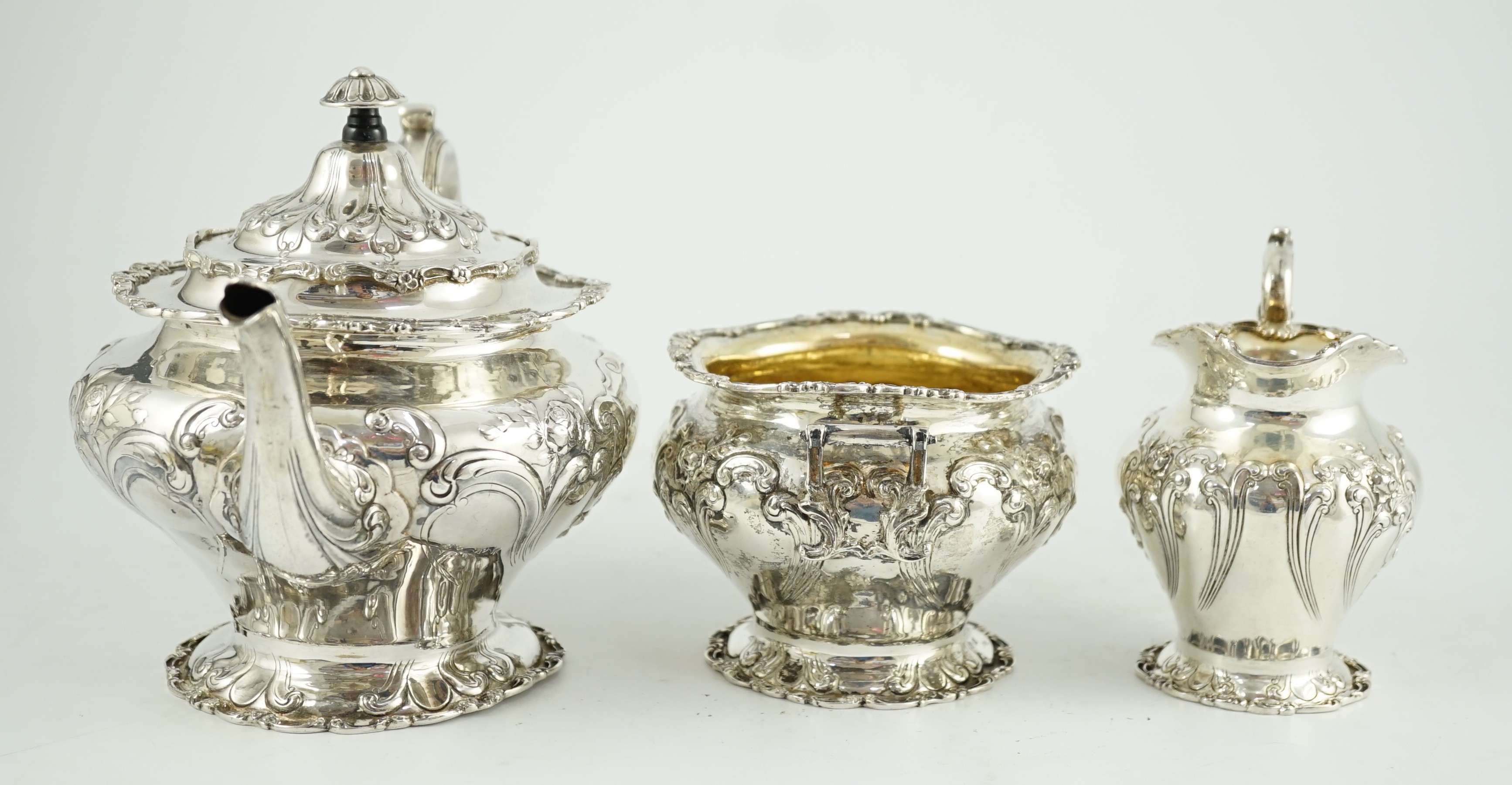 An Edwardian Scottish repousse silver three piece tea set, by Robert Scott